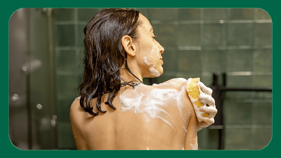 Lady taking a shower applying body wash Lady taking a shower applying body wash